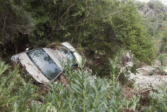 Z avtom 15 metrov v globino: Voznik pristal na strehi, zdravniško pomoč poiskal kar sam