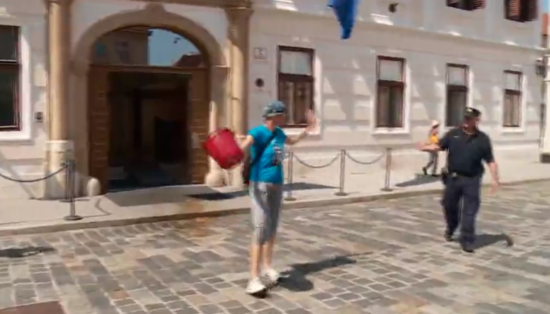 Novinarka pred vladno palača zlila vedro gnojnice