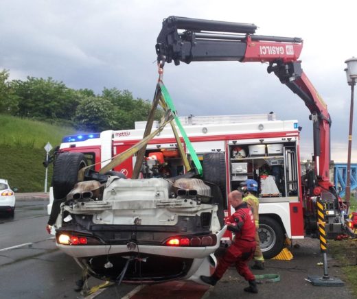 Avto v globel, ena oseba ostala ujeta