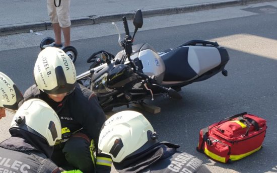 Trčenja dve motorjev in dveh osebnih vozil, nastradala motoristka