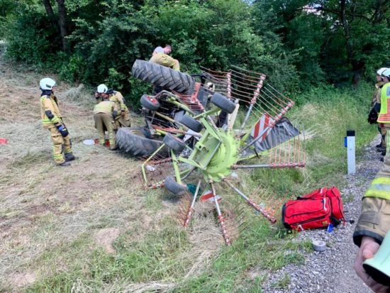 Traktor zdrsnil s pobočja, obstal ukleščen za hišo, v njem pa oseba